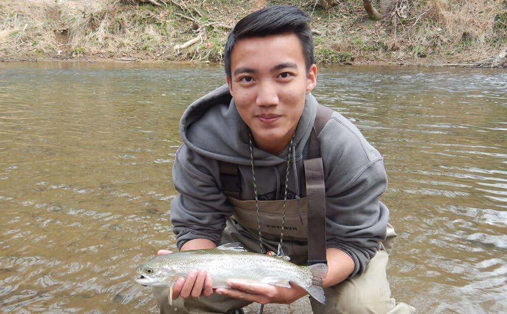 student shows off a fish he caught